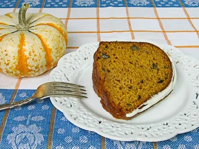 A slice of Pumpkin Pecan Bundt Cake with a cream cheese glaze