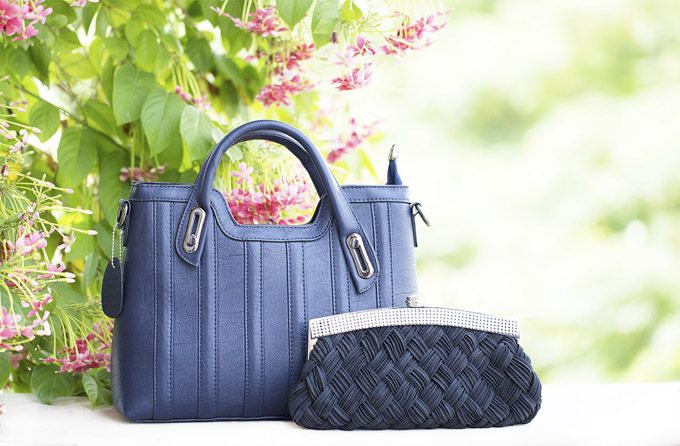 Two blue handbags outdoors to illustrate a Poshmark review
