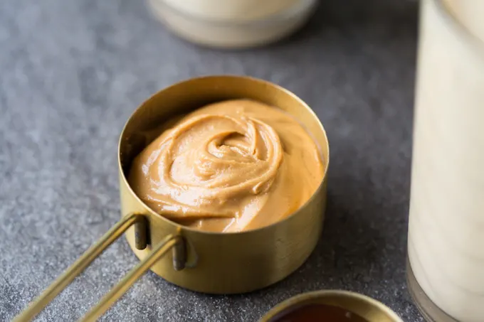 Peanut butter in a gold measuring cup