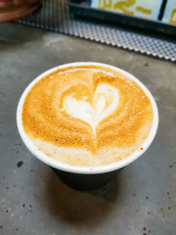 Heart in a to go cup of oat milk cappuccino