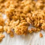 Crunchy granola on parchment paper on a baking sheet