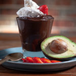 Chocolate avocado mousse topped with whipped cream and strawberries