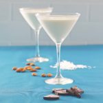 Chocolate Almond Coconut Martini or Almond Joy Martini on a blue surface with ingredients shown