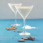 Chocolate Almond Coconut Martini or Almond Joy Martini on a blue surface with ingredients shown