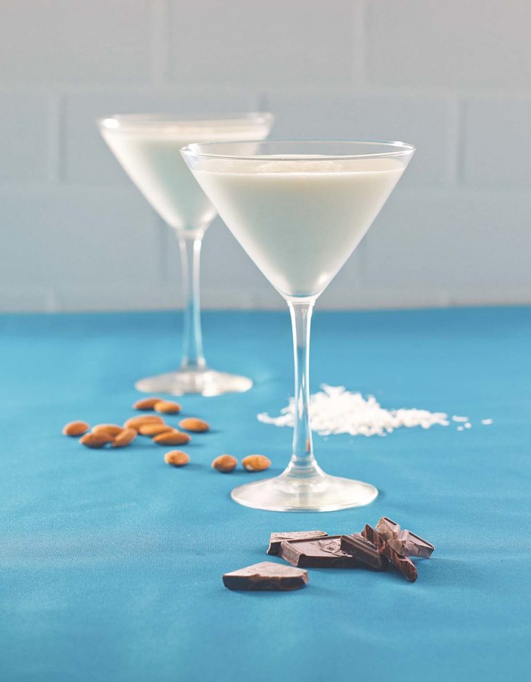 Chocolate Almond Coconut Martini or Almond Joy Martini on a blue surface with ingredients shown
